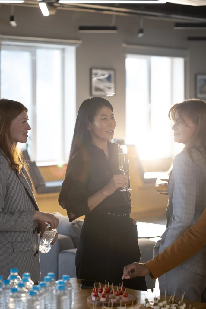 Three women socializing at an office reception